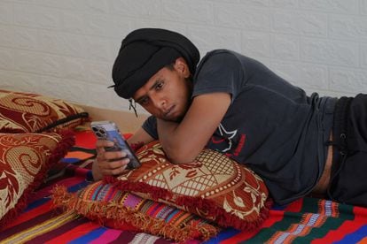 Un vecino de Al Bat consulta su teléfono móvil en el interior de una de las estancias empleadas por los hombres de esta comunidad beduina no reconocida por Israel.